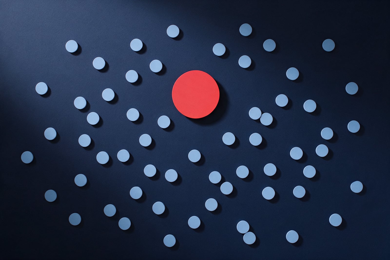 Círculo vermelho-coral sólido numa parede azul-escura, rodeado por pequenas formas azul-claras